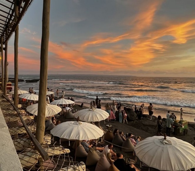 Bãi biển Canggu buổi chiều với người lướt sóng và quán cà phê ven biển