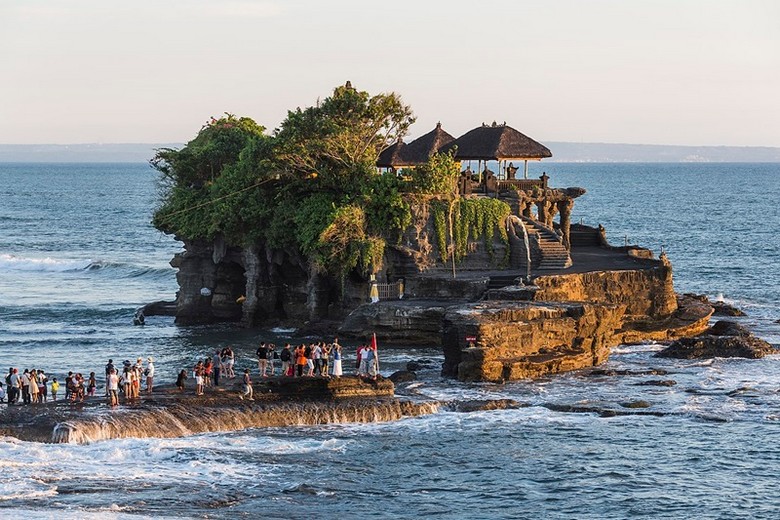 Khách mặc sarong truyền thống trước cổng đền Tanah Lot lúc hoàng hôn