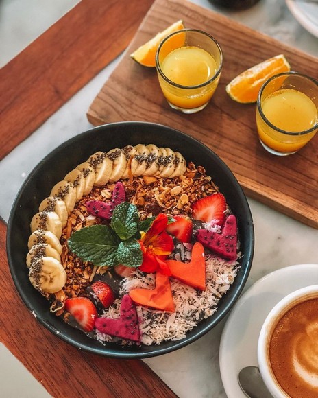 Ly smoothie bowl và granola chay tại một quán cà phê sáng tại Ubud với ánh nắng buổi sớm