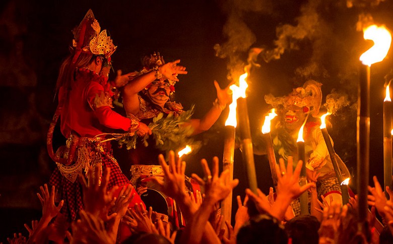 Nghệ nhân múa Kecak trong trang phục truyền thống với mặt nạ Ravana, ánh lửa phía sau