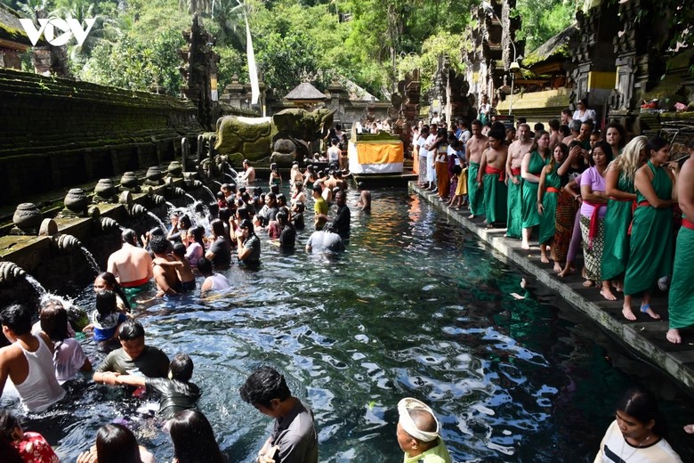 Nghi lễ tắm nước thiêng tại đền Tirta Empul, khách tham quan mặc sarong tham gia nghi lễ melukat truyền thống