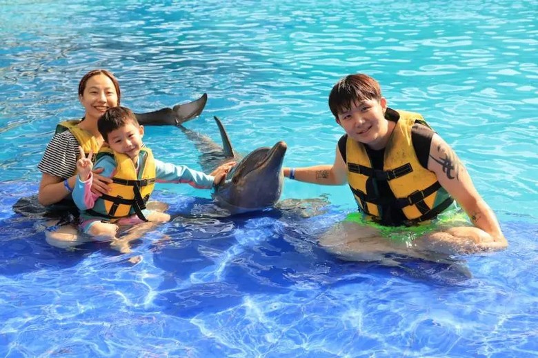 Trẻ em mặc áo phao chơi ở khu hồ nông của công viên nước Bali