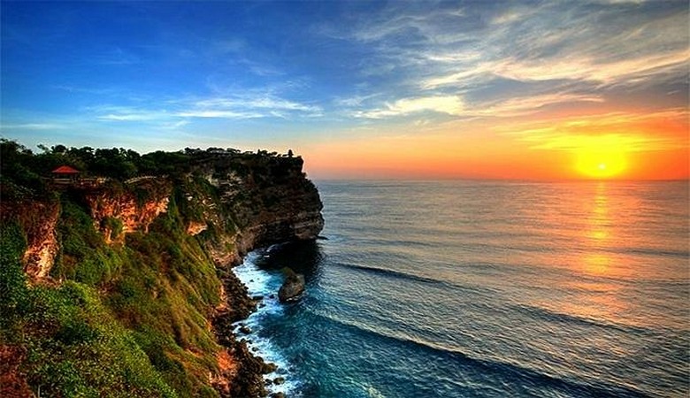 Vách đá đền Uluwatu nhìn từ xa, sóng biển đập vào chân đá bên dưới