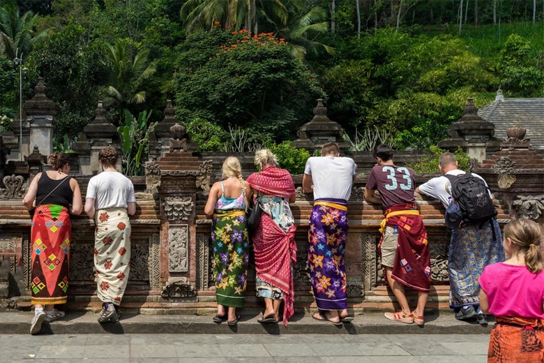 Du khách quấn sarong xem biểu diễn trong sân đền